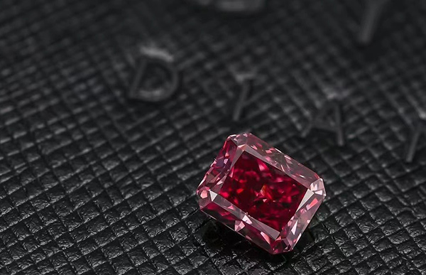 Radiant-cut Argyle red diamond on textured black leather surface